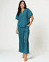 Woman wearing a teal outfit on a white background