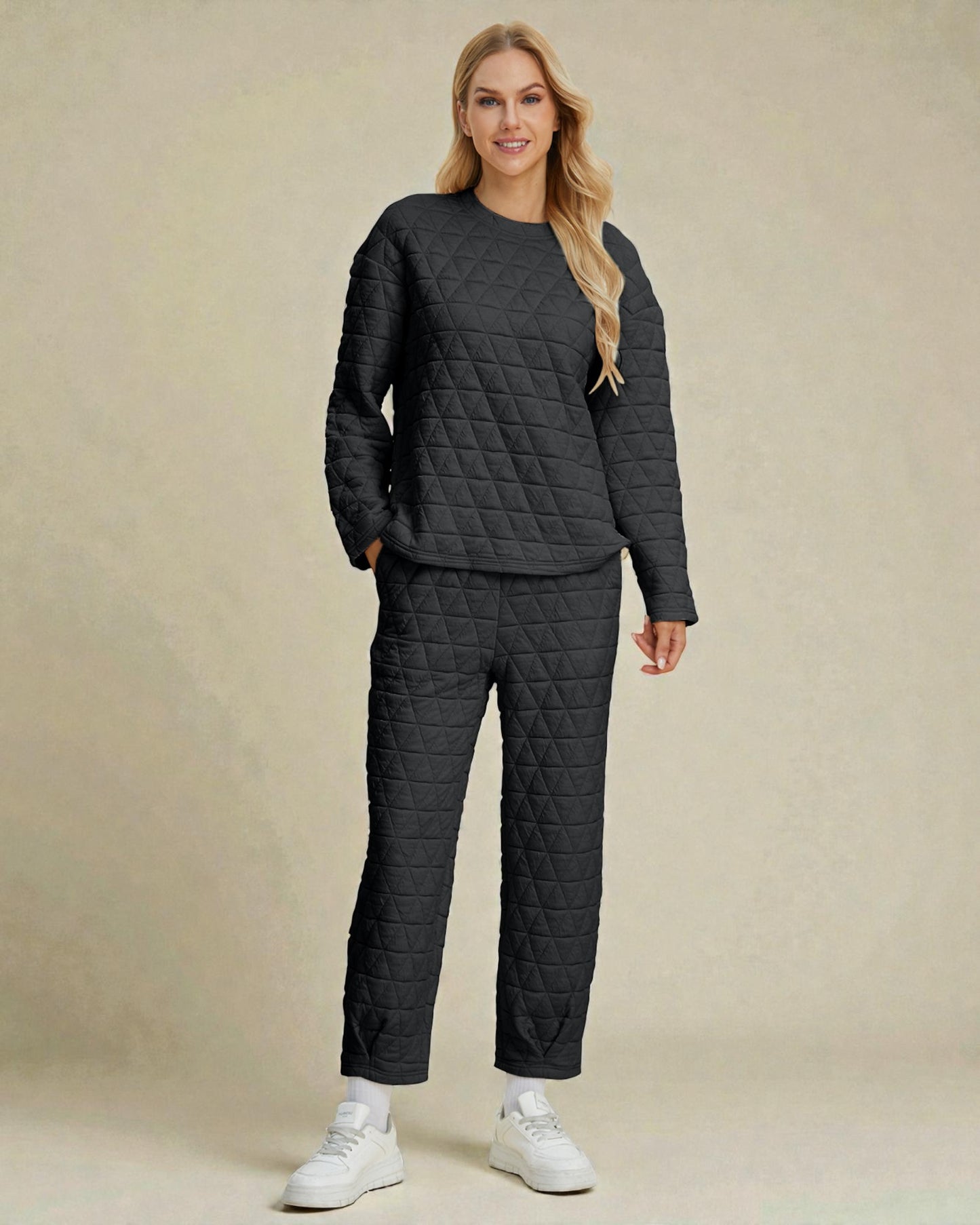 Woman wearing a quilted dark gray outfit on a beige background