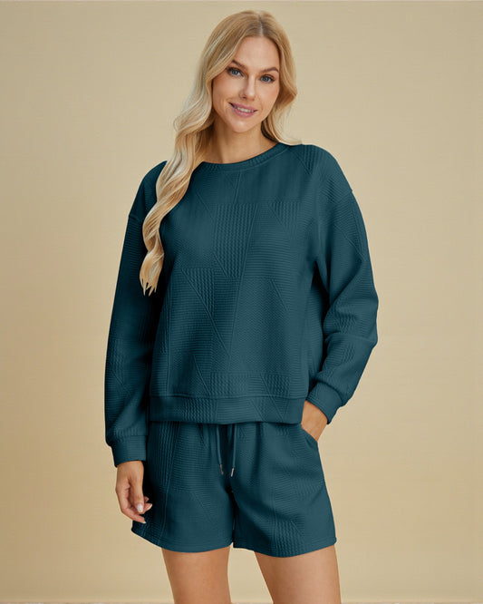 Woman wearing a teal sweater and shorts set on a beige background