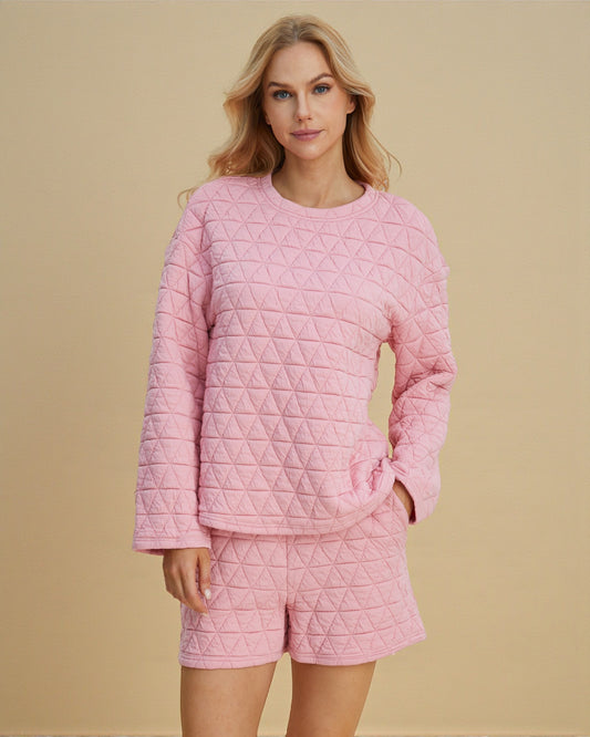 Woman wearing a pink quilted outfit on a beige background
