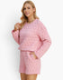 A woman modeling a light pink quilted two-piece loungewear set consisting of a long-sleeve top and matching shorts, set against a plain white studio background.
