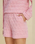 Pink quilted pajama set on a beige background