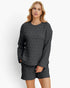 A woman modeling a dark gray quilted two-piece lounge set consisting of a long-sleeve top and matching shorts, shot against a plain white studio background.