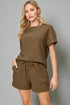 Woman wearing a brown outfit against a gray background