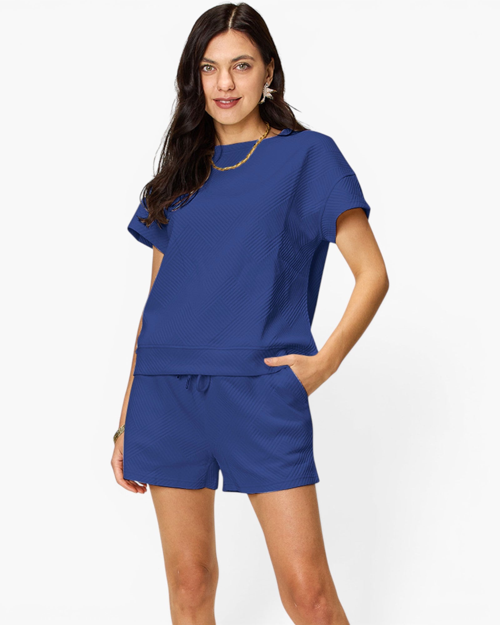 A woman modeling a matching royal blue lounge set consisting of a short-sleeve top and drawstring shorts, photographed against a clean white studio background.