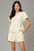 Woman wearing a light-colored outfit against a gray background