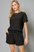 Woman wearing a black outfit with a gray background