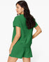 A woman wearing a matching green short-sleeve knit top and shorts set, shown from a three-quarters back view against a plain white studio background.