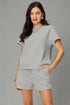 Woman wearing a gray outfit with a textured pattern against a gray background