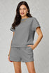 Woman wearing a gray textured outfit on a plain background