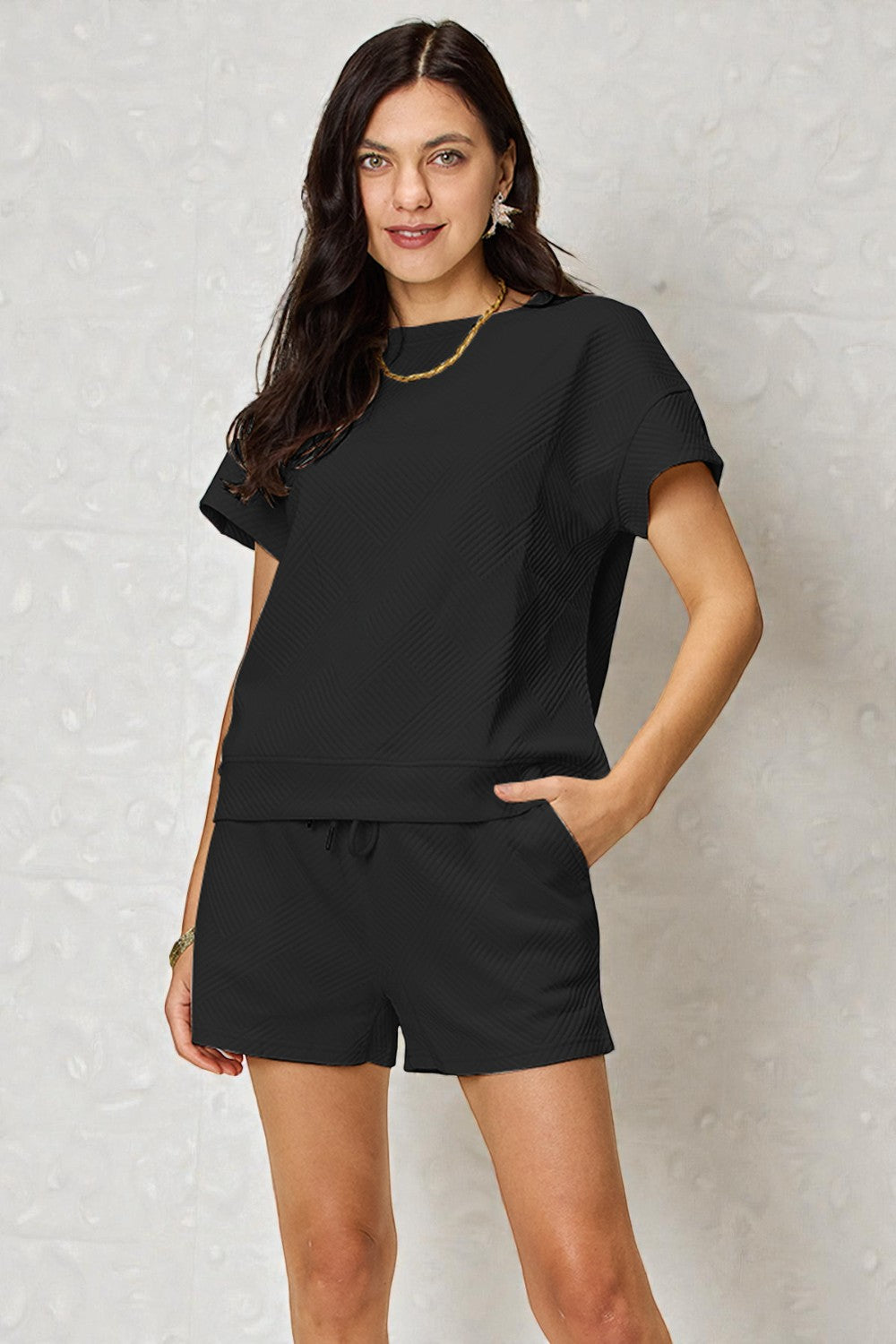 Woman wearing a black outfit with a plain background