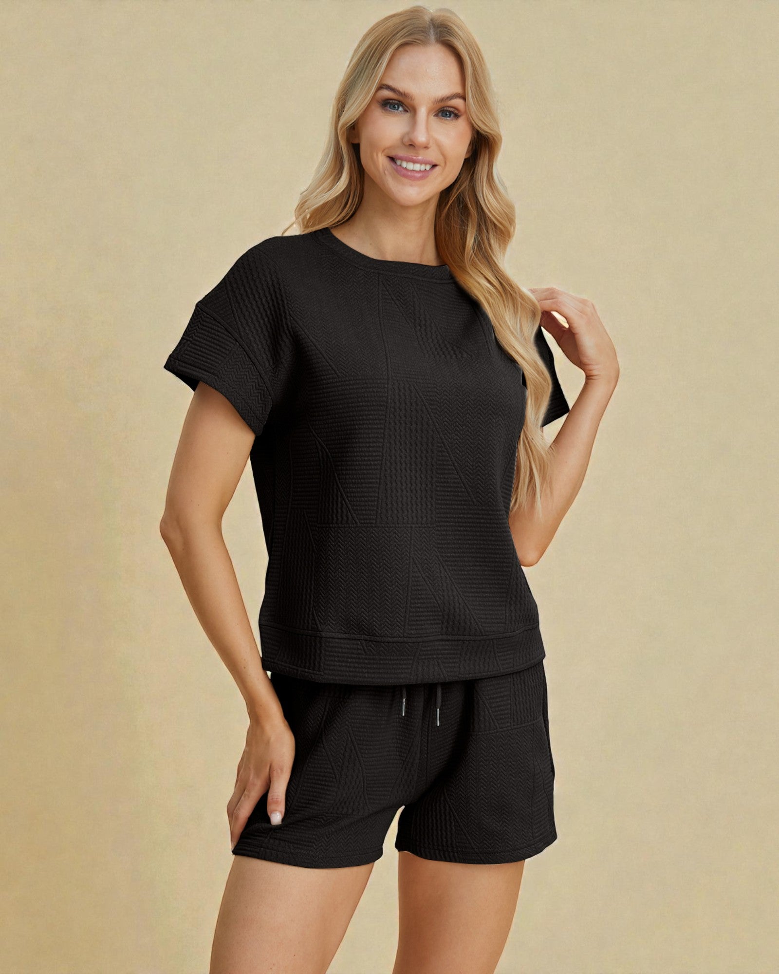 Woman wearing a black outfit on a beige background