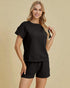 Woman wearing a black outfit on a beige background