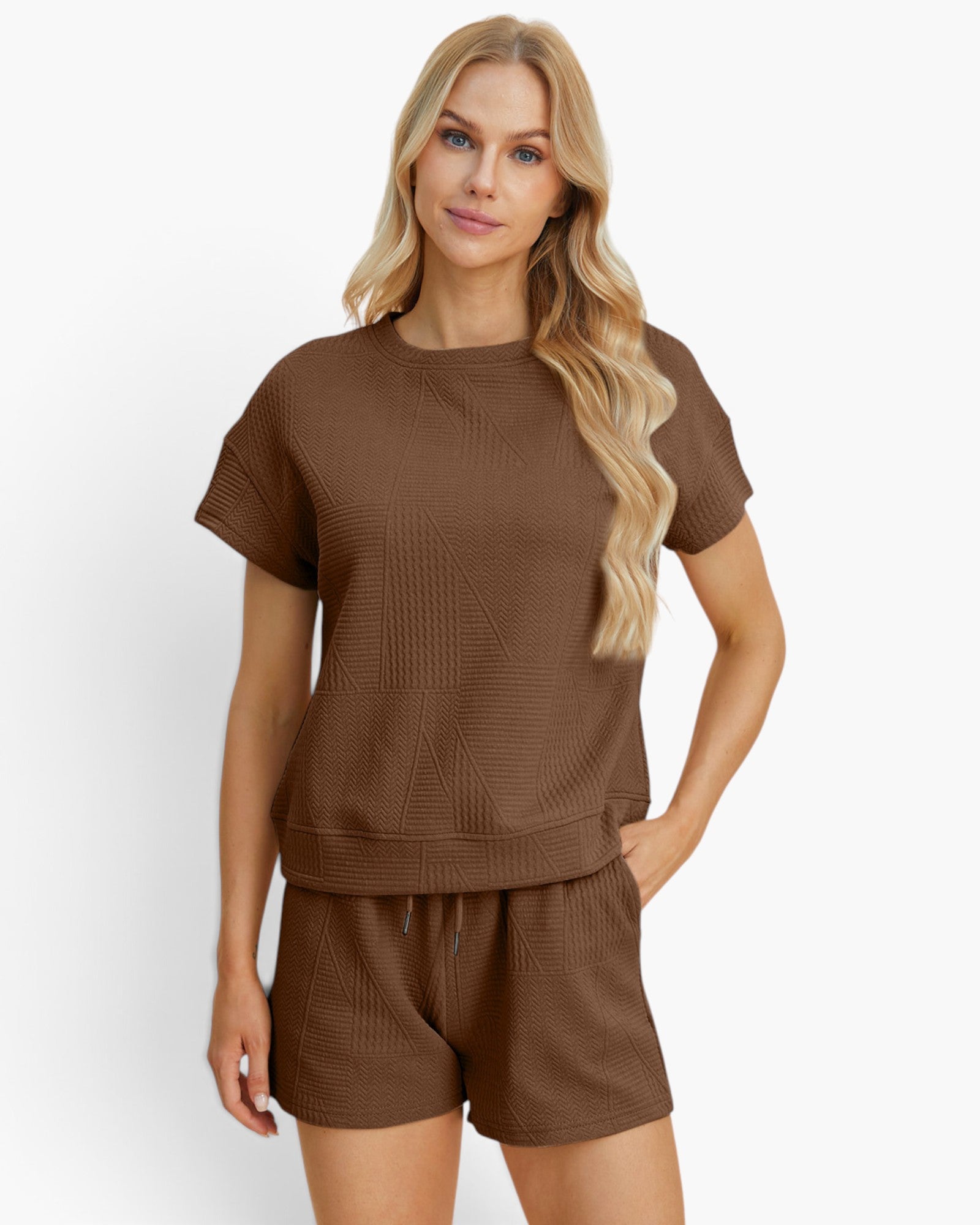A blonde model wearing a matching brown short-sleeve knit top and shorts set against a clean white studio background.