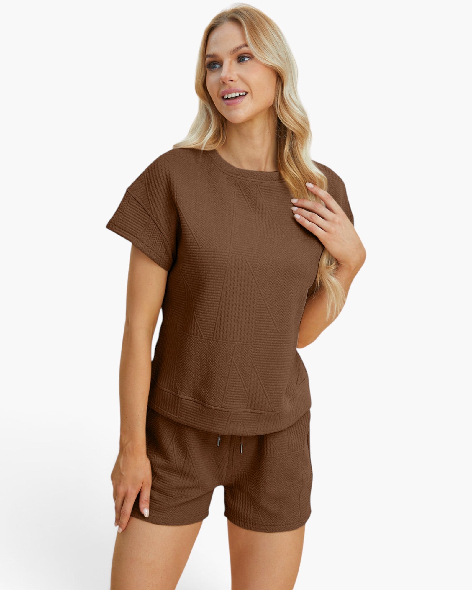 A woman modeling a matching brown lounge set consisting of a short-sleeve textured top and coordinating shorts against a plain white studio background.
