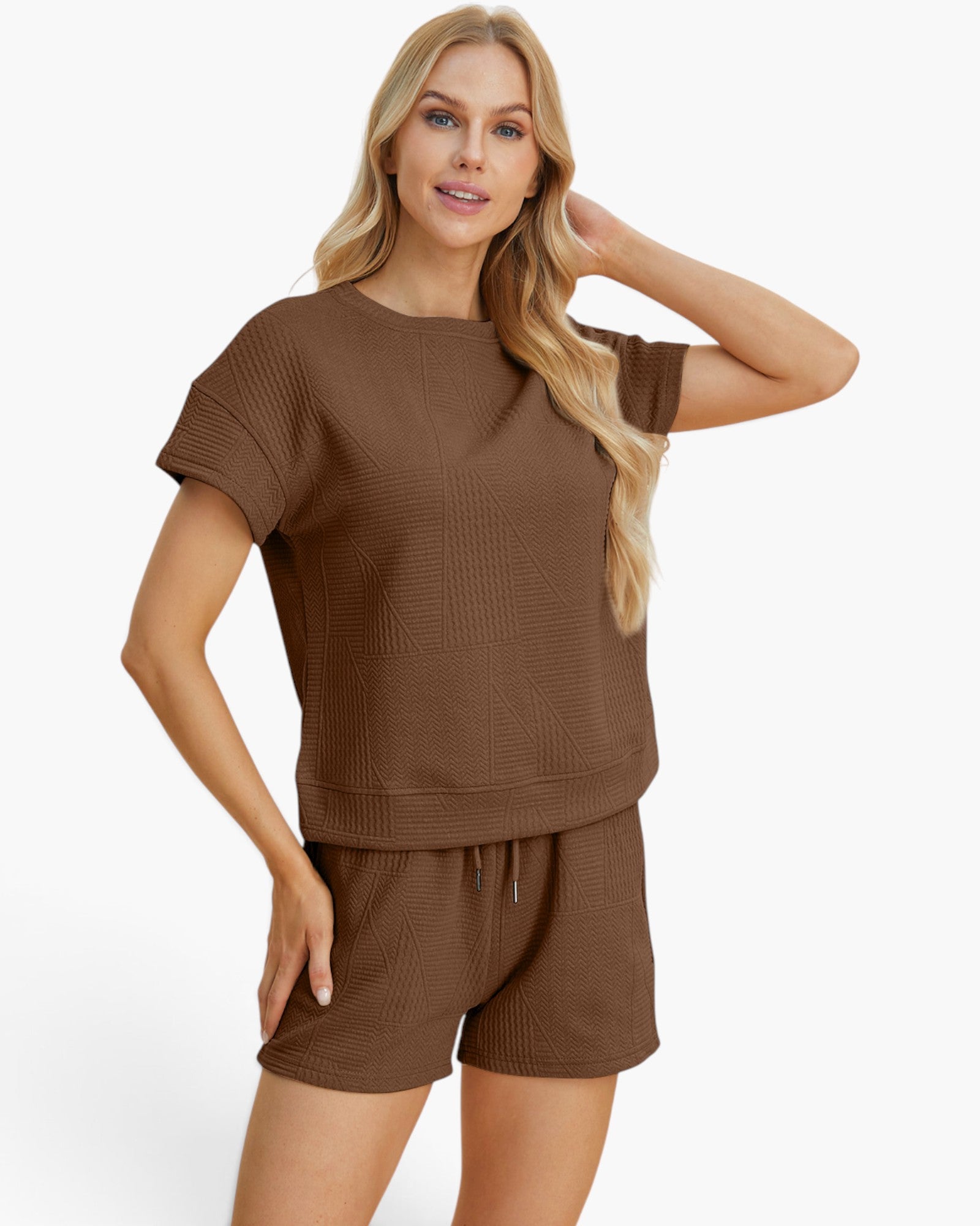 A woman modeling a matching brown lounge set consisting of a short-sleeve top and shorts with a textured waffle-weave pattern, against a plain white background.
