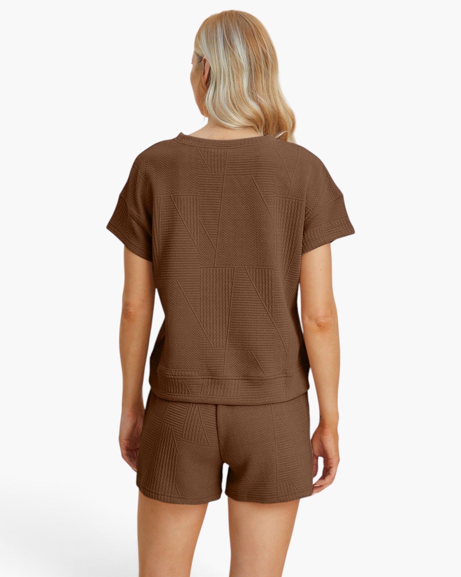 A woman shown from the back wearing a brown short-sleeve cropped top and matching shorts with a subtle geometric waffle texture, against a plain white studio background.