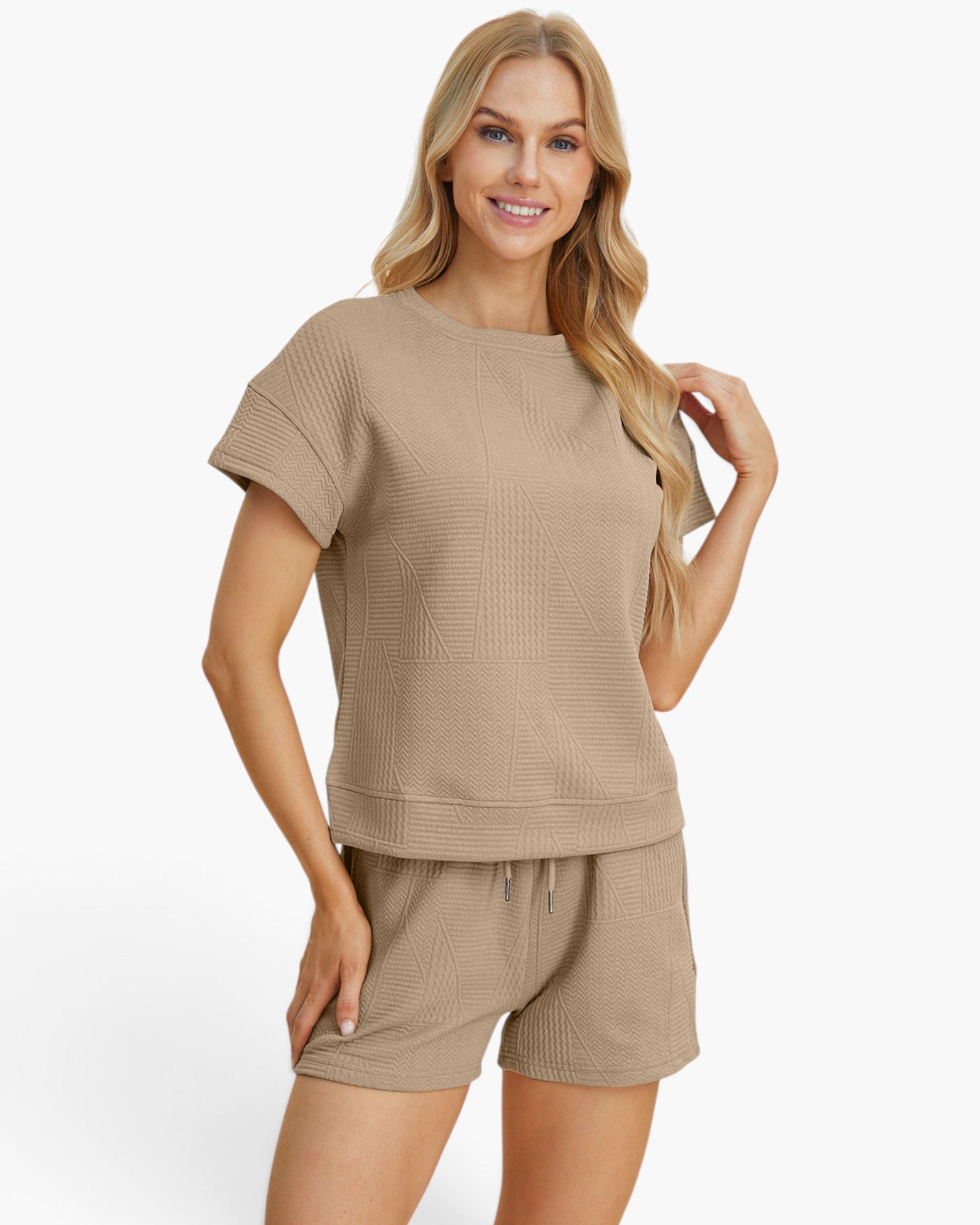 A woman modeling a matching beige short-sleeve waffle-knit top and shorts set against a clean white background.