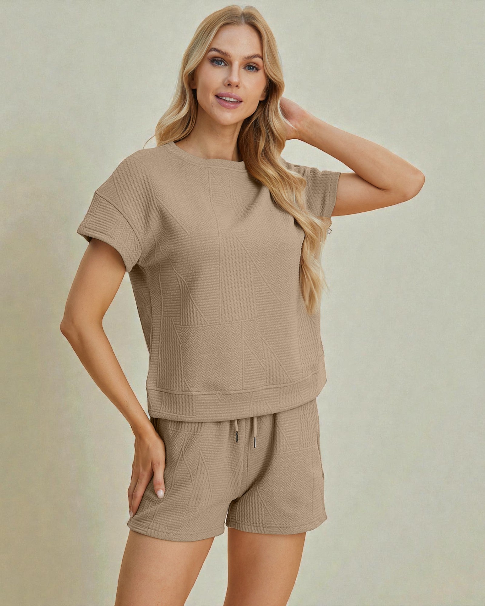 Woman wearing a beige knit outfit on a plain background