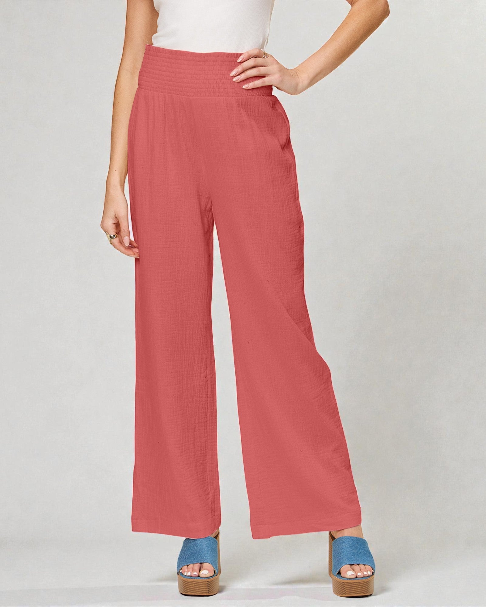 Person wearing coral wide-leg pants on a plain background