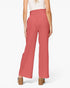 A model shown from the back wearing high-waisted, wide-leg trousers in a dusty rose pink color, paired with a white top and brown block-heel sandals, against a plain white studio background.