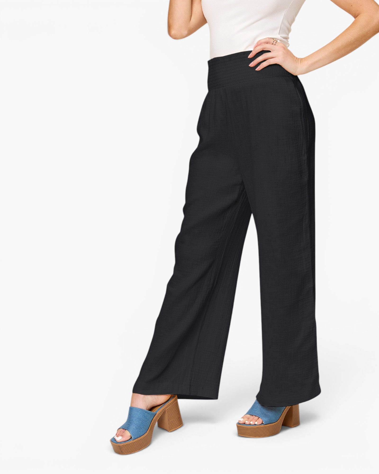 A model wearing black wide-leg cropped pants, styled with a white top and blue platform sandals, shown from the waist down against a plain white background.