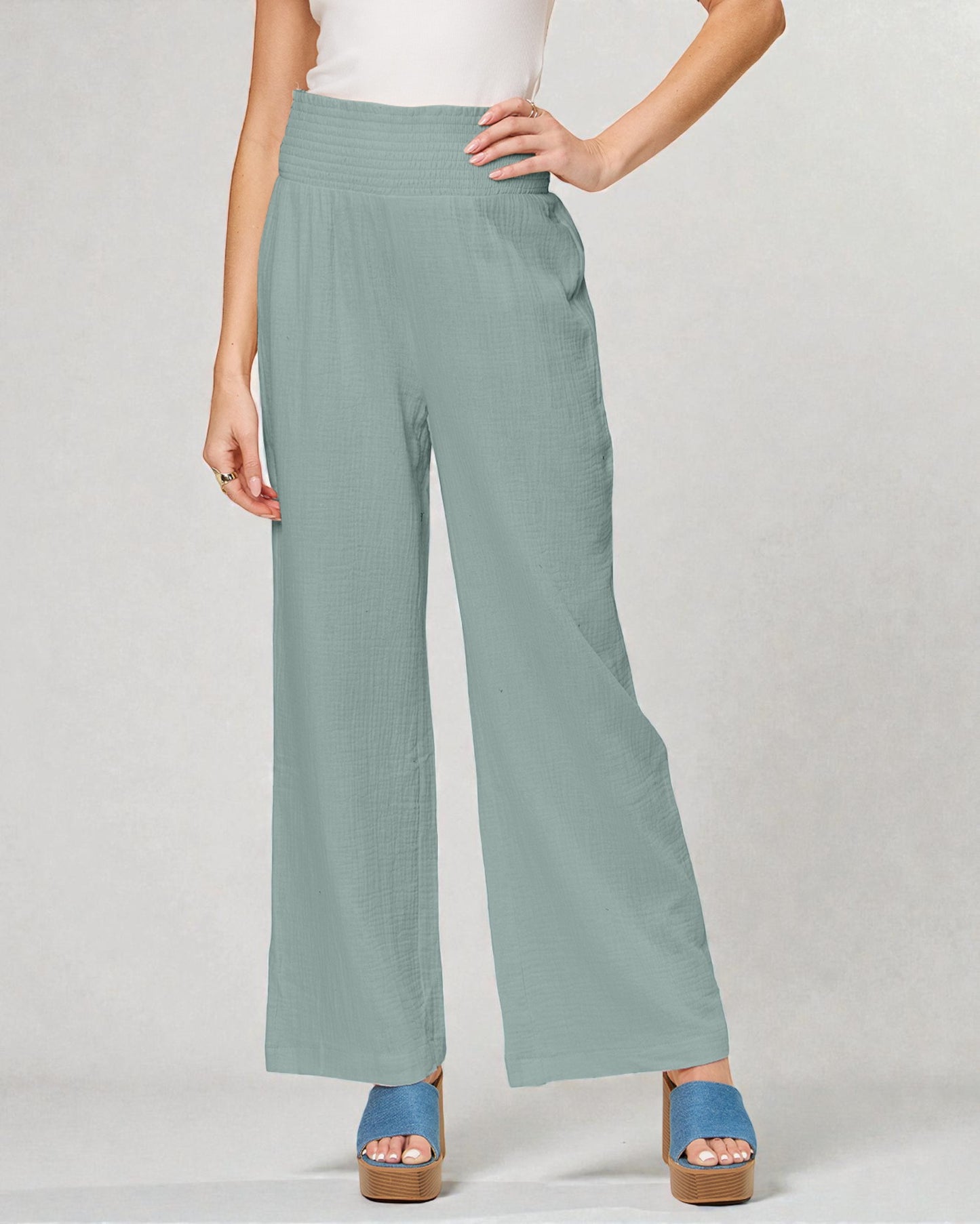 Person wearing light green wide-leg pants on a plain background