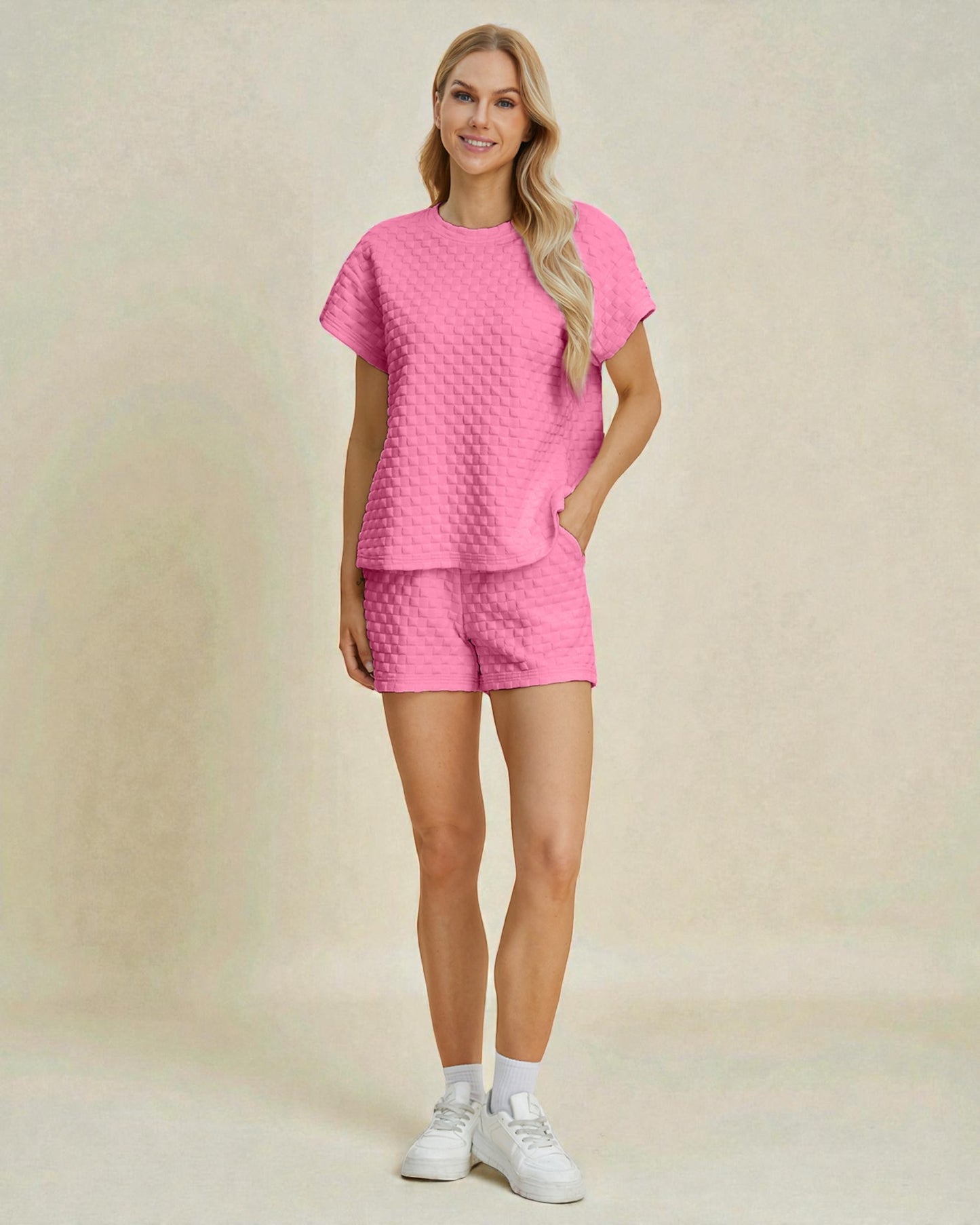 Woman wearing a pink textured outfit on a beige background