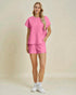 Woman wearing a pink textured outfit on a beige background