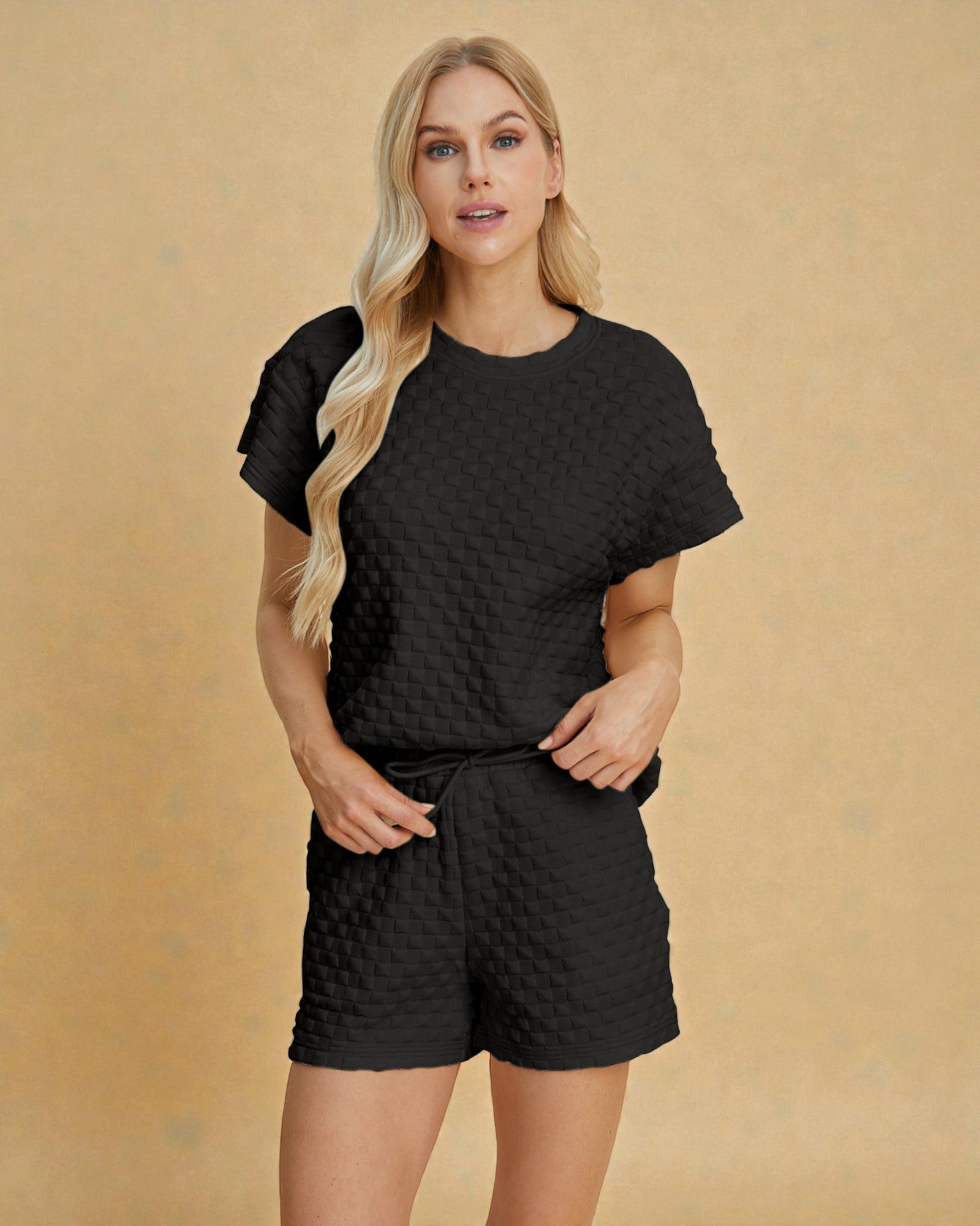 Woman wearing a black textured outfit on a beige background