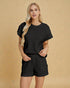 Woman wearing a black textured outfit on a beige background