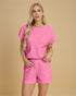 Woman wearing a pink textured outfit on a beige background