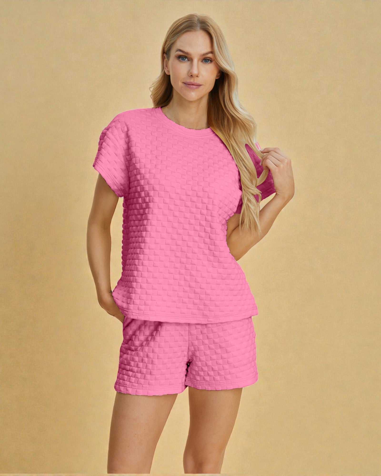 Woman wearing a pink textured outfit on a beige background