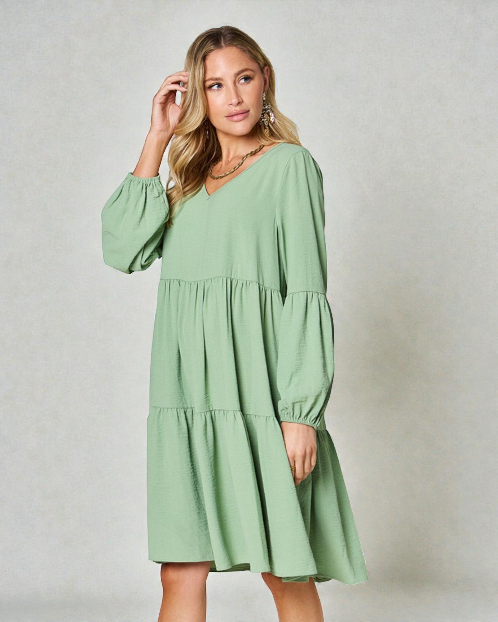 Woman wearing a green dress against a plain background
