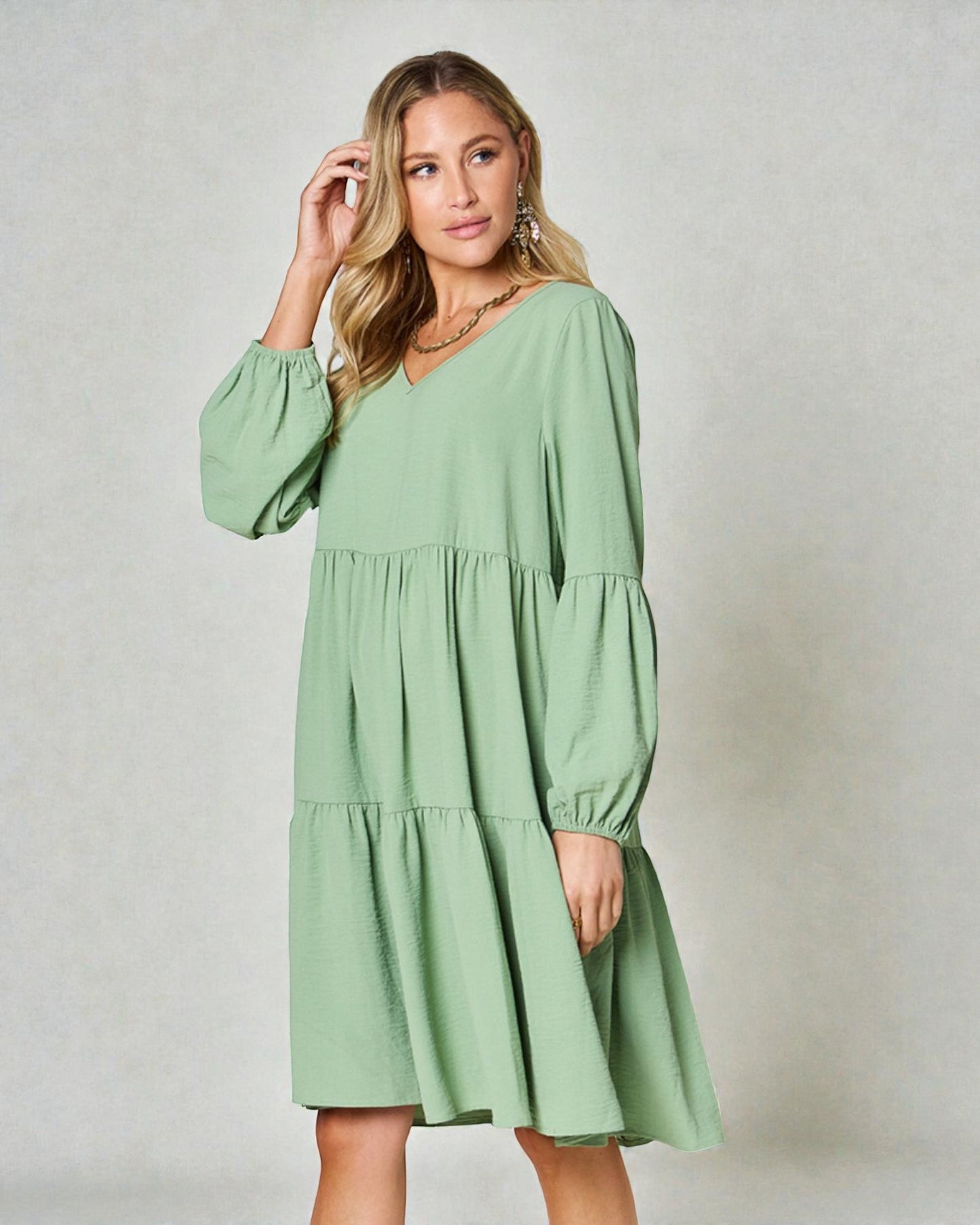 Woman wearing a green dress against a plain background