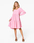 A woman modeling a light pink long-sleeve tiered dress with a scoop neckline, photographed against a clean white studio background.