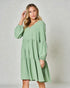Woman wearing a green dress against a plain background