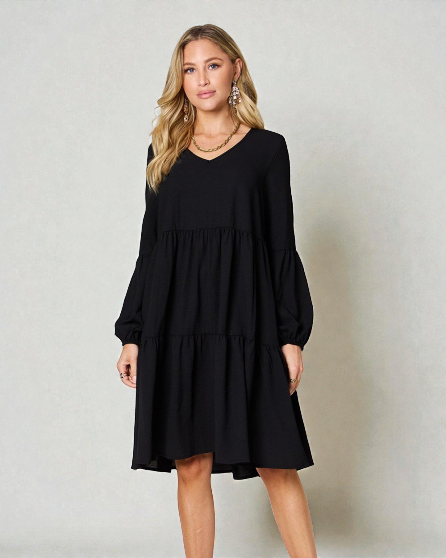 Woman wearing a black dress against a plain background