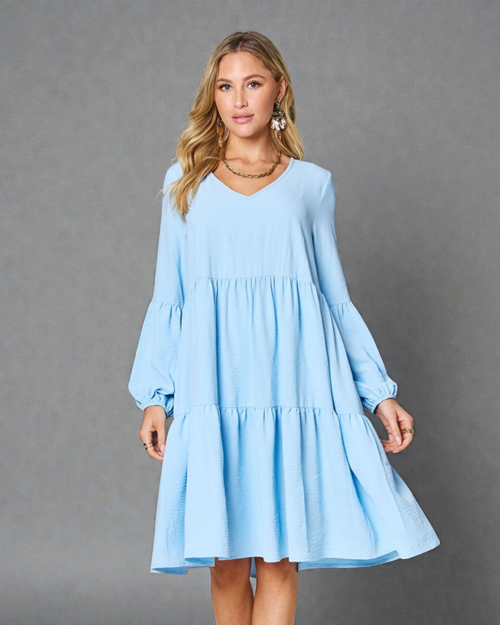 Woman wearing a light blue dress against a gray background