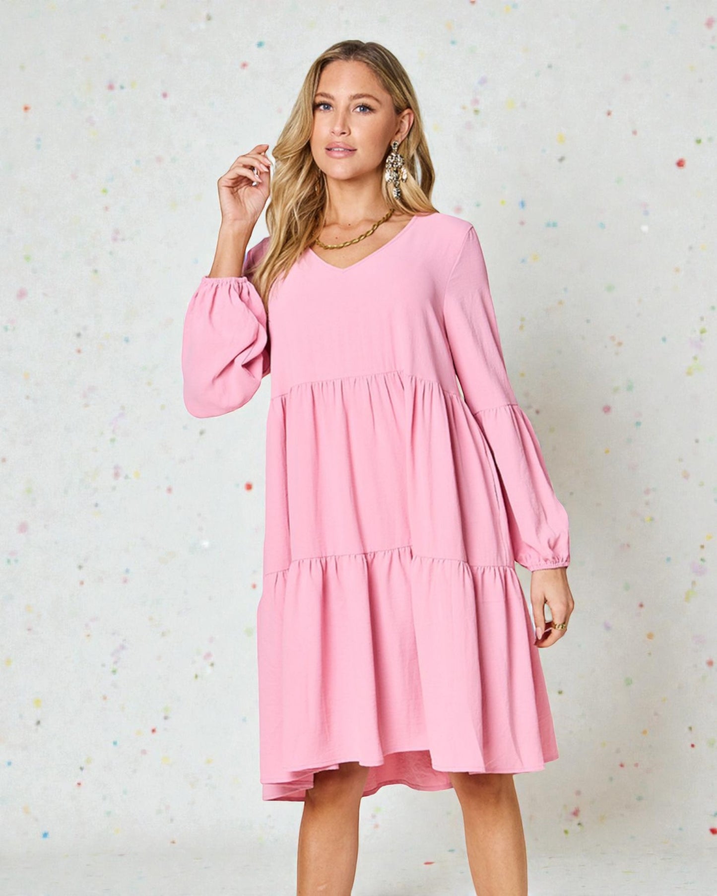 Woman wearing a pink dress against a light background