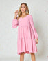 Woman wearing a pink dress against a light background