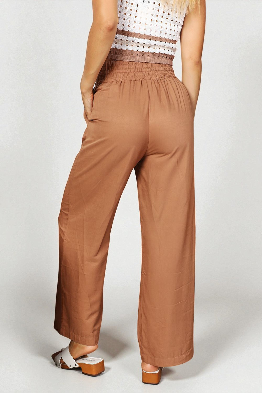 Brown wide-leg pants worn by a person on a white background