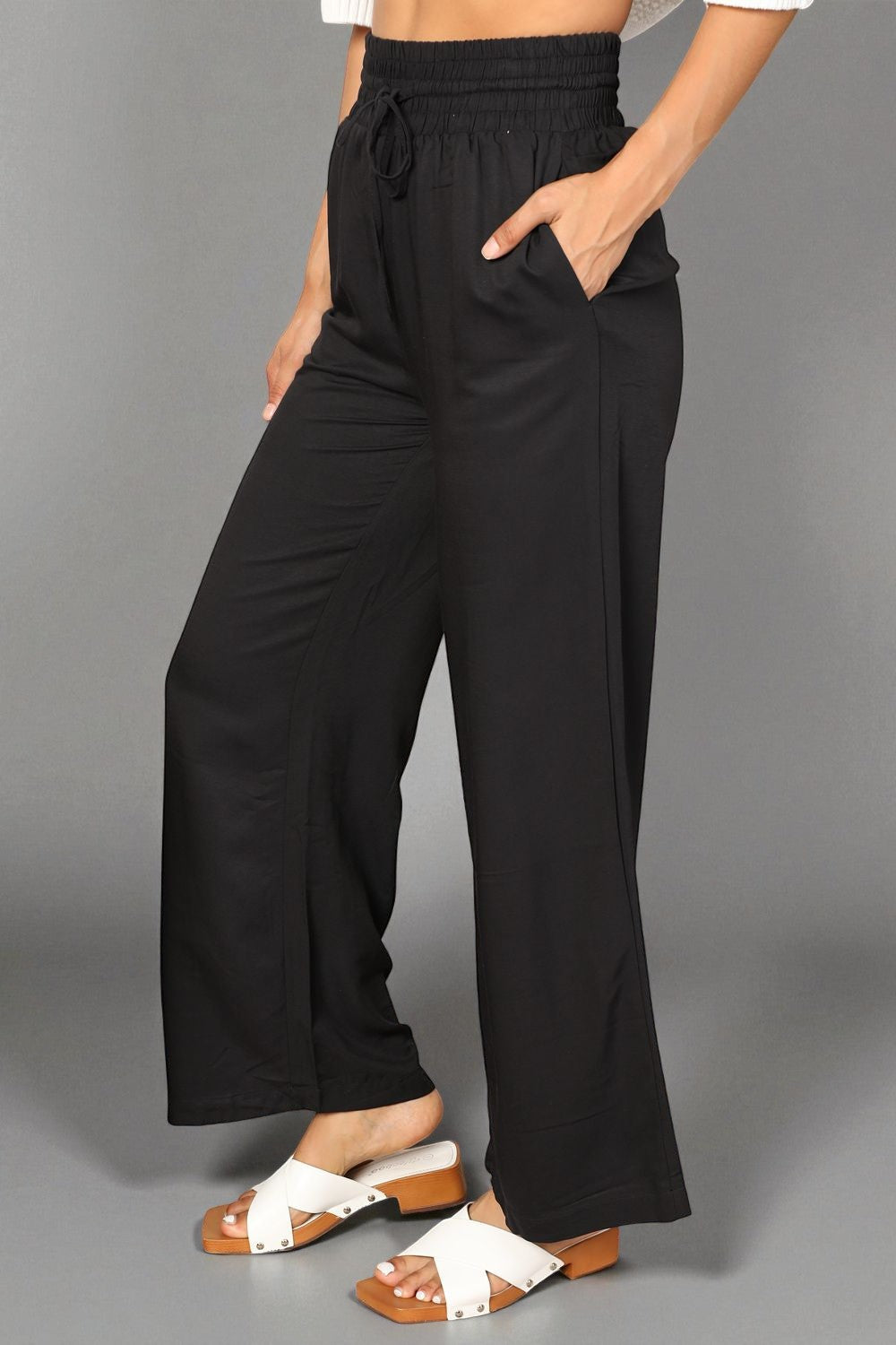 Black wide-leg pants worn by a person on a gray background