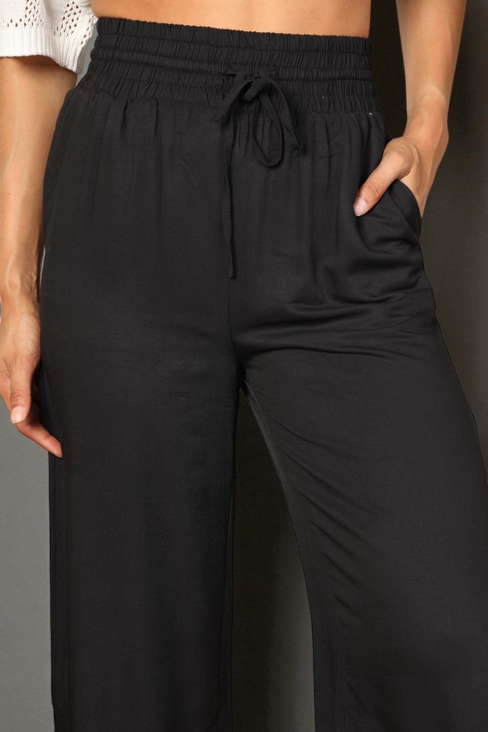 Black pants worn by a person against a neutral background