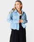 Woman wearing a light blue denim jacket on a white background