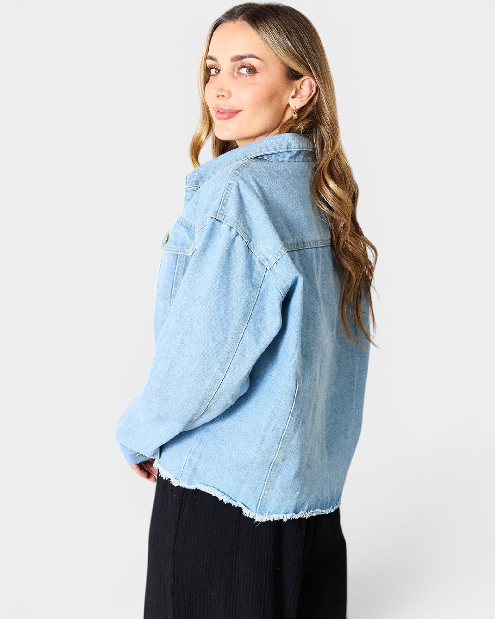 Woman wearing a light blue denim jacket on a white background