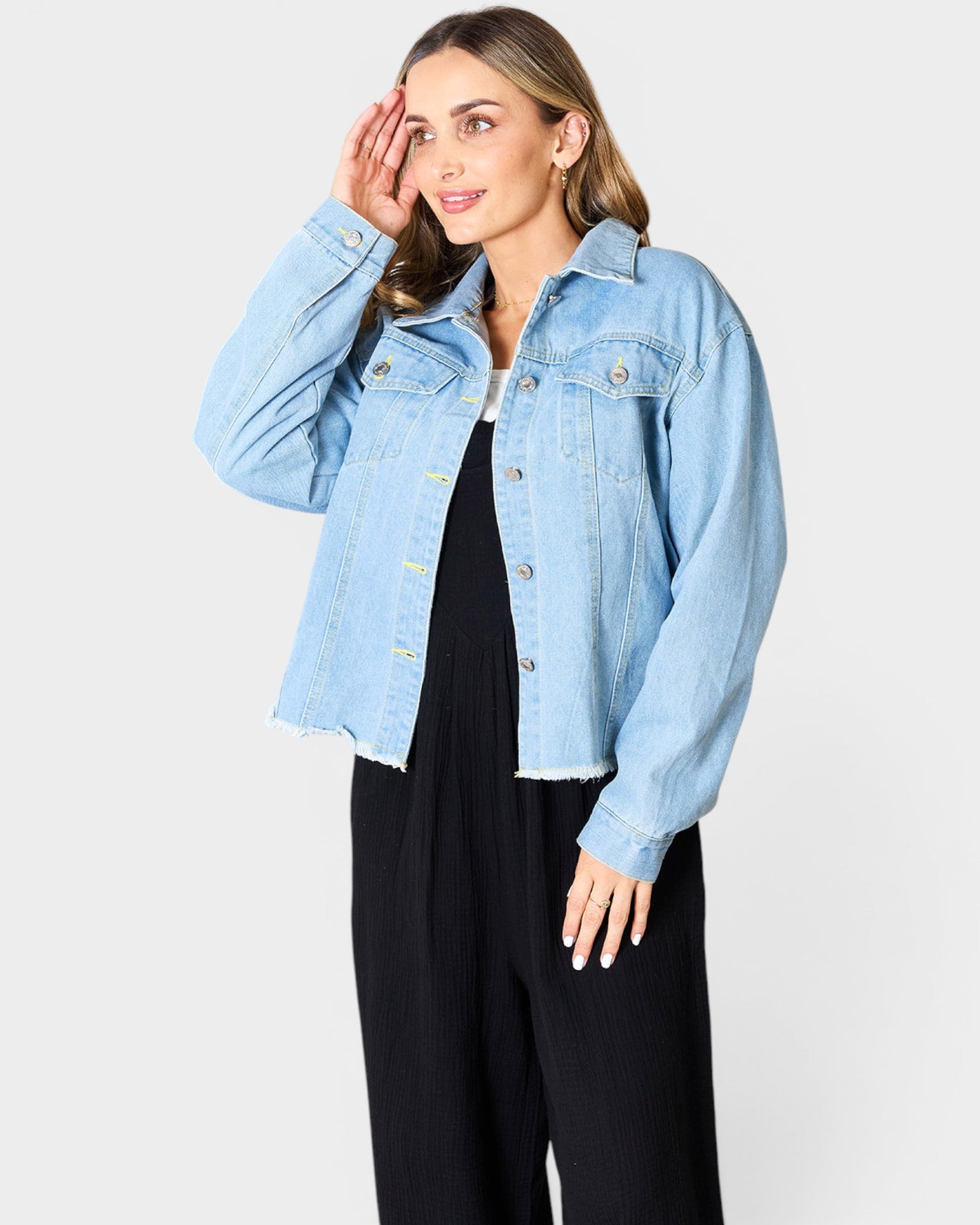 Woman wearing a light blue denim jacket on a white background