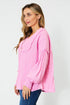 Woman wearing a pink blouse with long sleeves on a white background
