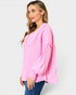 Woman wearing a pink blouse with long sleeves on a white background