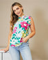 Woman wearing a colorful floral sleeveless top against a beige background